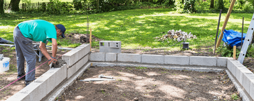 Construction d’un muret avant l’installation d’une serre de jardin LAMS